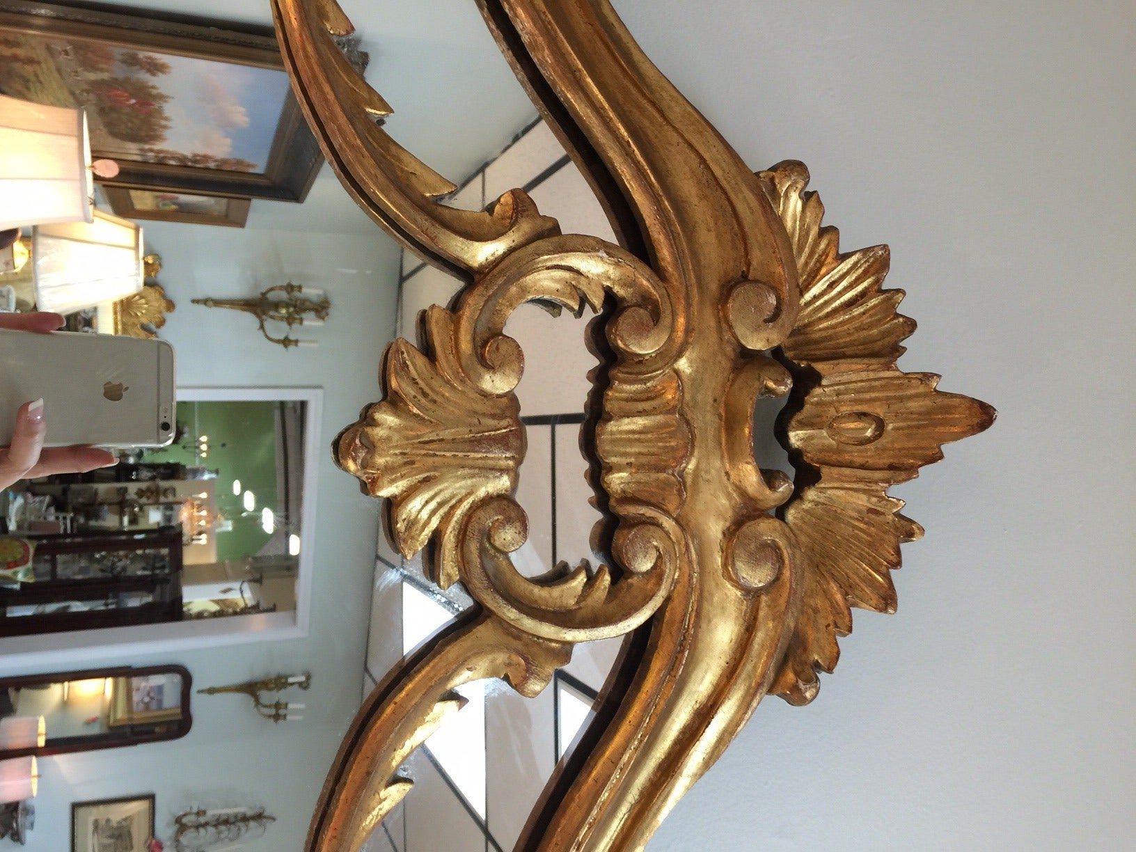 Regency style statement mirror is elaborately carved and sweetly gilded. It is in perfect vintage condition.