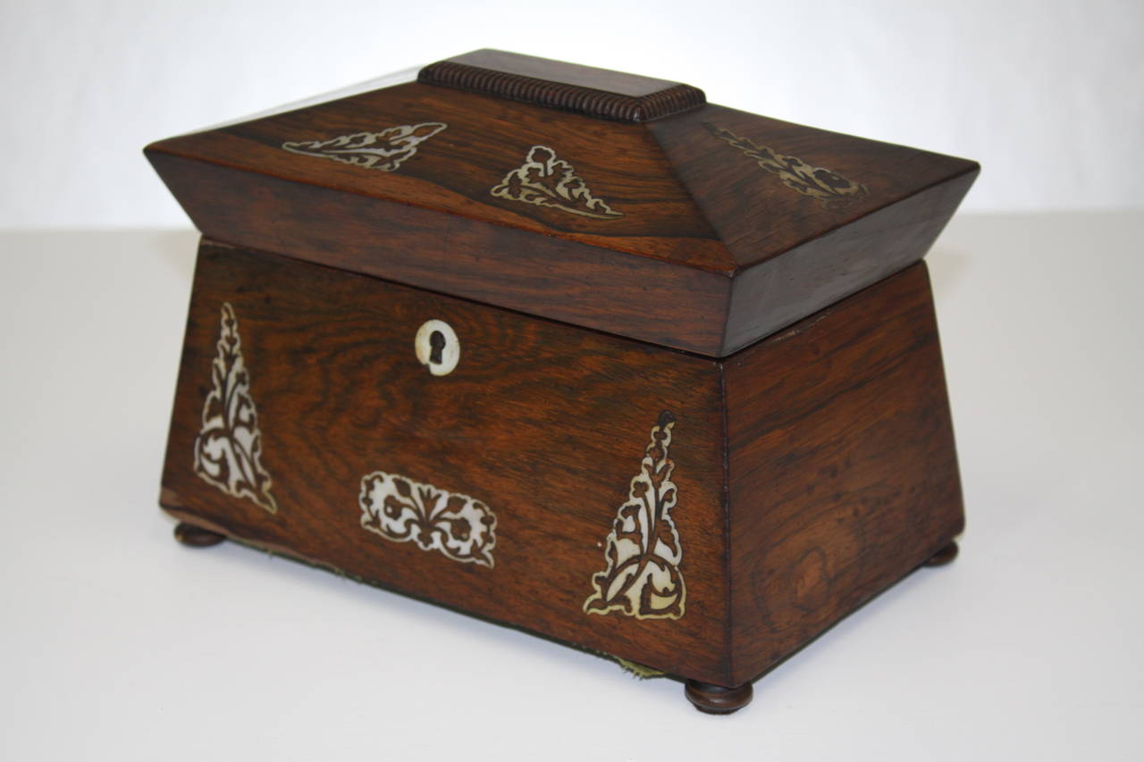 William IV rosewood tea caddy with mother-of-pearl inlays, two lidded interior wells. The box lid's underside line with embossed paper.