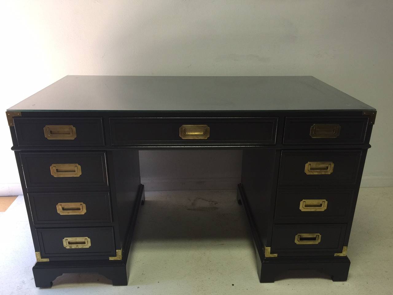 This strong vintage desk is ready for round two in its life and is spiffed up with a new coat of charcoal lacquer and just polished brass hardware. Simple, elegant, timeless, it will grace your home or office. Top it with a brass lamp, an elegant
