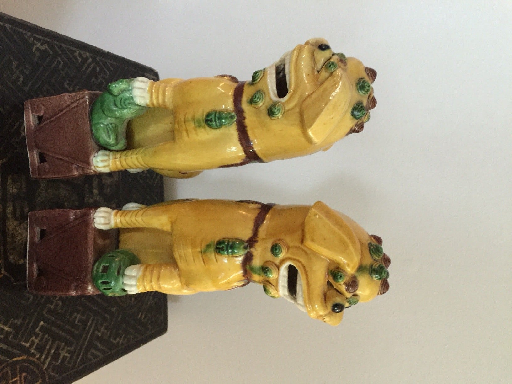 These Majolica Foo Dogs are in perfect vintage condition. The female or yin dog hold her pup and the male or yang dog holds a ball.  He protects the home, she nurtures it.  This pair has lots of decorative detail with the individually placed eyes,