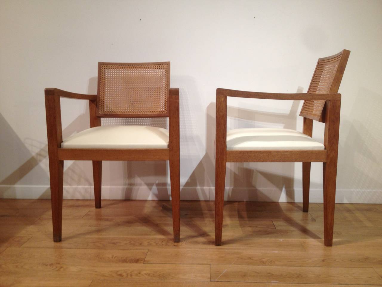 Four armchairs in oak, canework and ivory or beige leather.
Designed by Emile Seigneur in 1951.