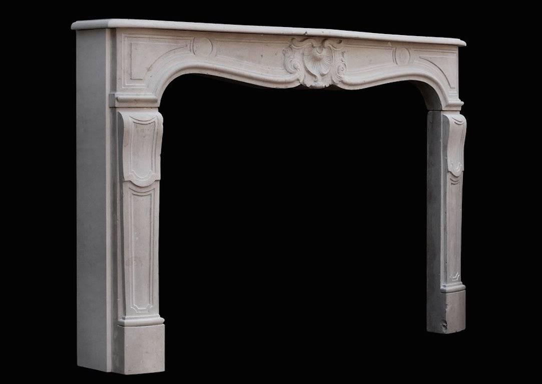 A well proportioned 19th century French Louis XV style limestone fireplace. The shaped, paneled jambs surmounted by carved frieze with motif to centre.

Measures:
Shelf width - 1630 mm - 64 1/8 in.
Overall height - 1085 mm - 42 3/4 in.
Opening