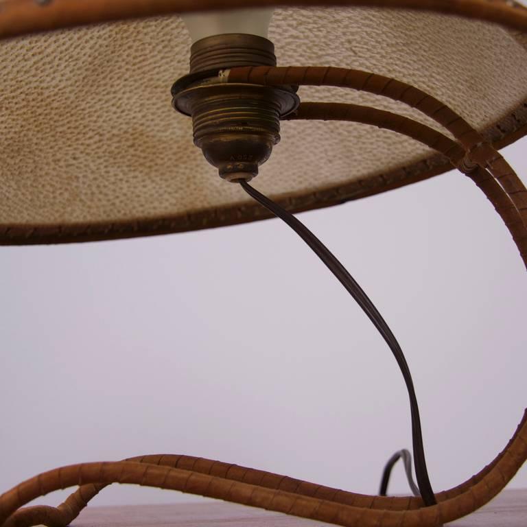 Very rare 1940s leather shade table lamp. The brass base is webbed in leather.
To be on the safe side, the lamp should be checked locally by a specialist concerning local requirements.

 