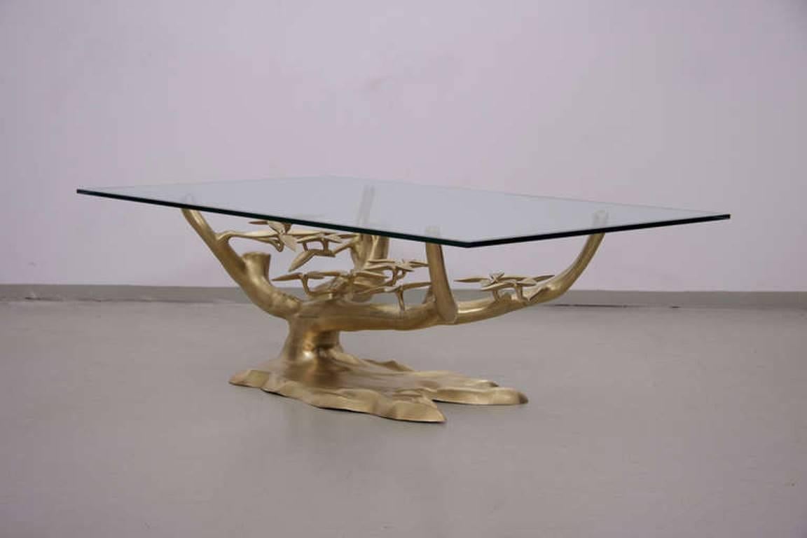 Rare brass coffee table with thick glass top and heavy brass base with natural leaf details. Glass top has a chip at corner. Base is excellent!