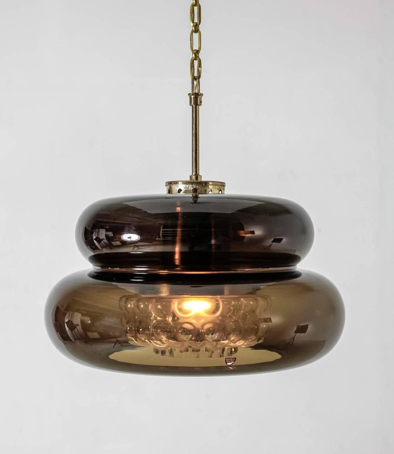A Carl Fagerlund glass 'Bubblan' pendant for Orrefors. The lamp is made of a smoky brown curved glass with a textured clear glass diffuser inside.

The lamp is in a good condition and labeled by Fagerlund.