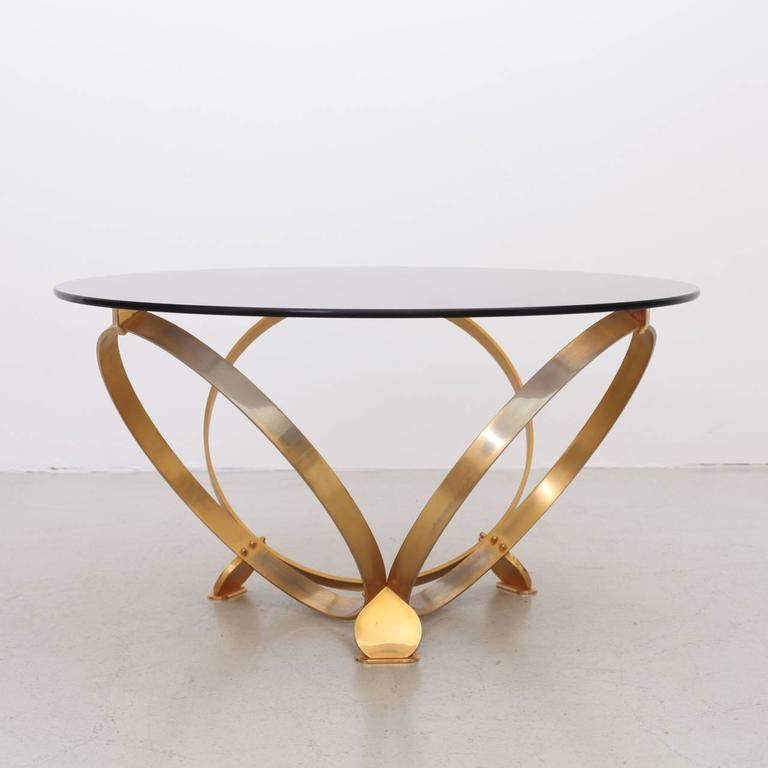 Wonderful coffee table with three solid geometric rings in brass with a floating glass top. Excellent condition.

