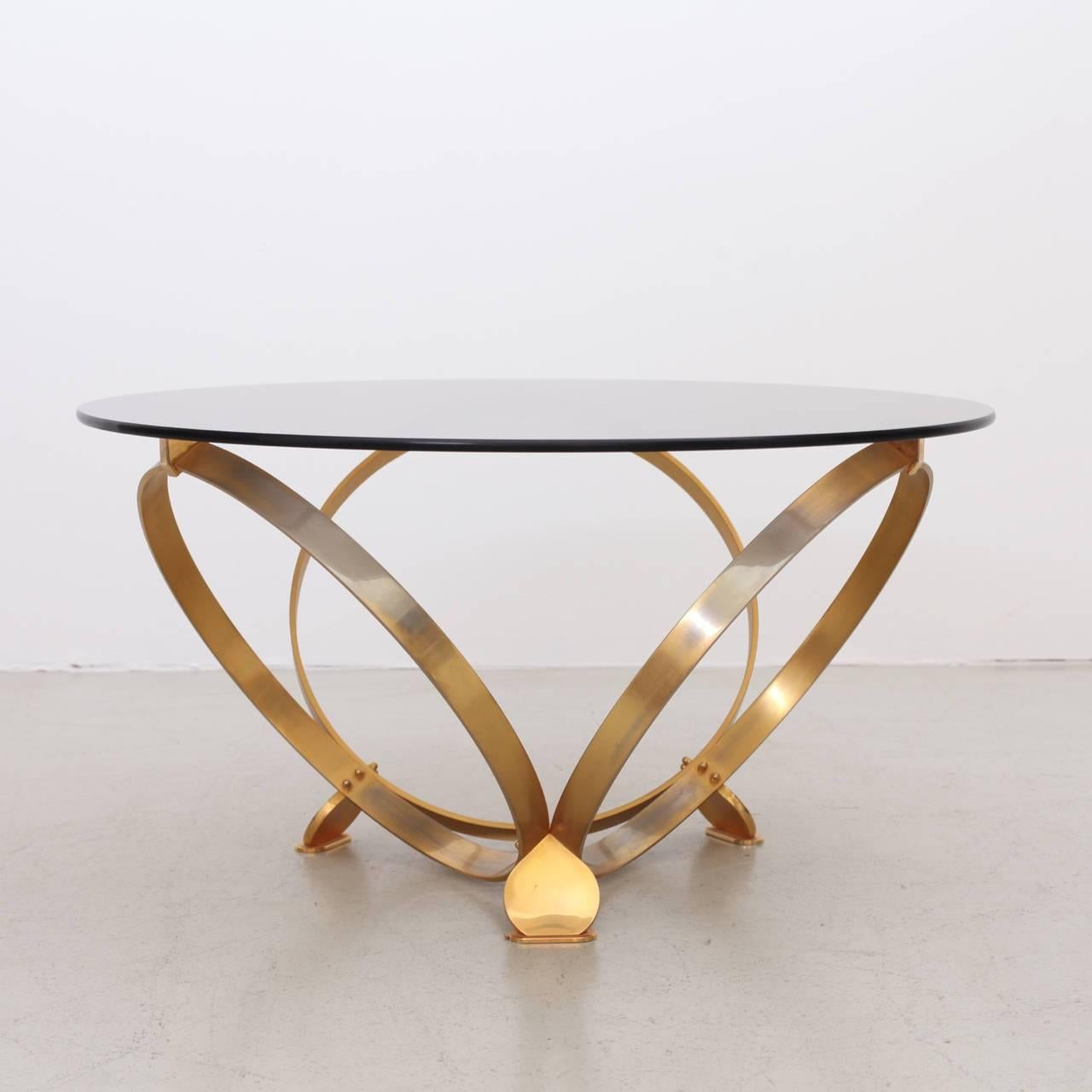 Wonderful coffee table with three solid geometric rings in brass with a floating glass top. Excellent condition.


