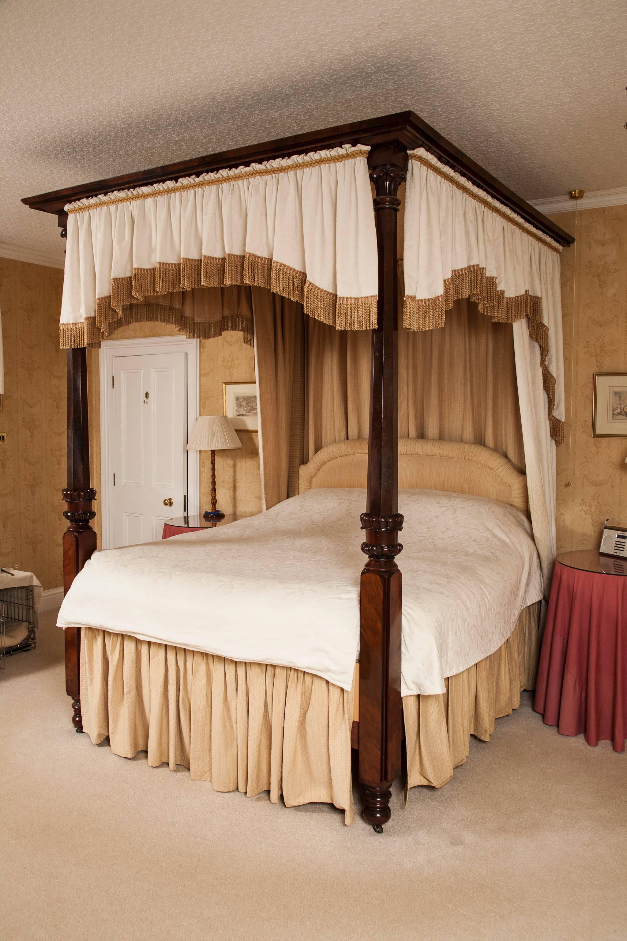 A fine 19th century mahogany four-poster bed. The front posts of square form to the lower part with central turned and stylized leaf carved collar and tapering octagonal upper part below leaf carved capitol, in the Gillows manner, and mahogany top