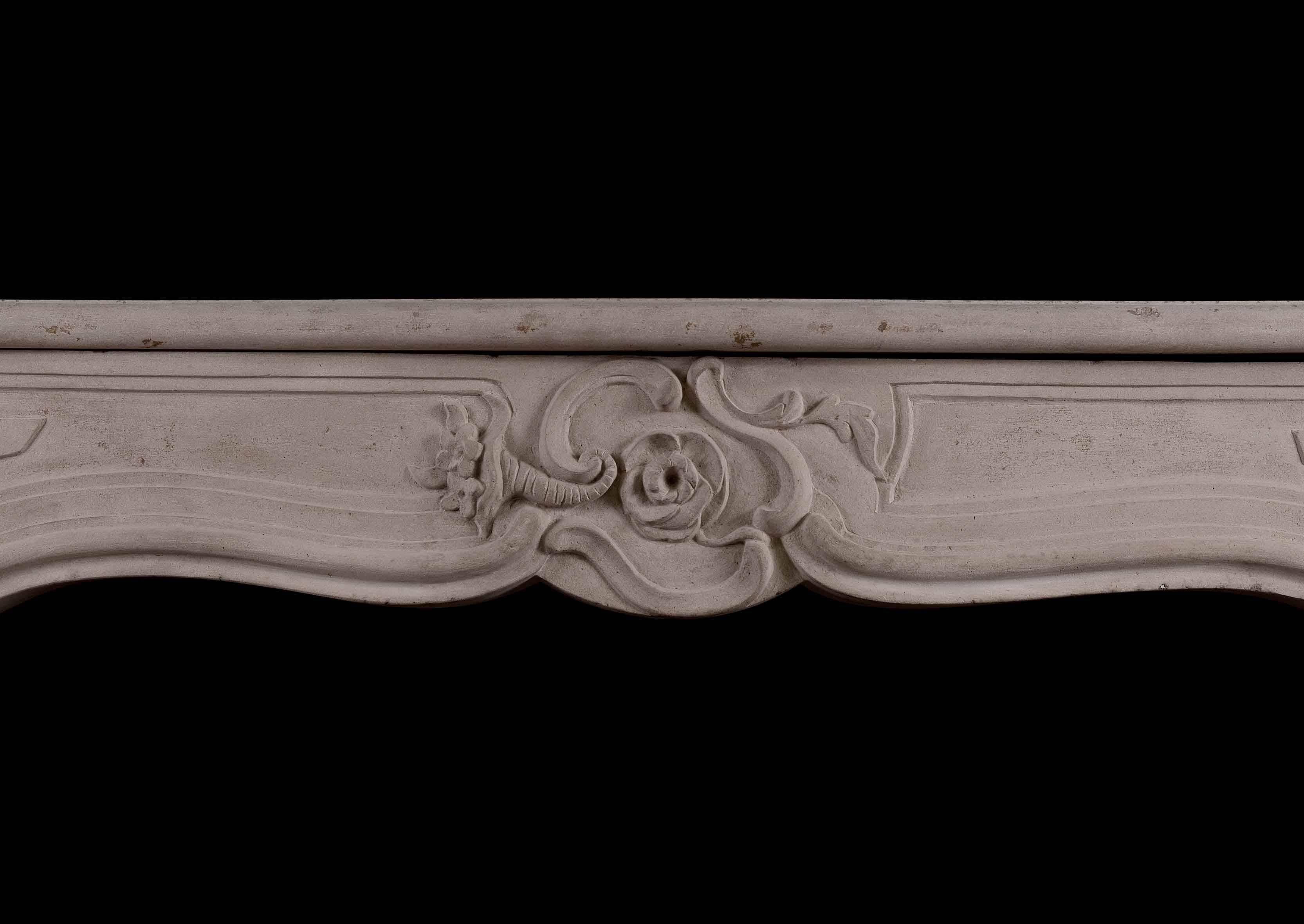 A good quality period 18th century Louis XV limestone fireplace. The paneled jambs with stiff leaves to bases, the carved frieze with flowers to center surmounted by shaped shelf. An unusual piece.

Shelf Width:	1300 mm      	51 1/8 in
Overall