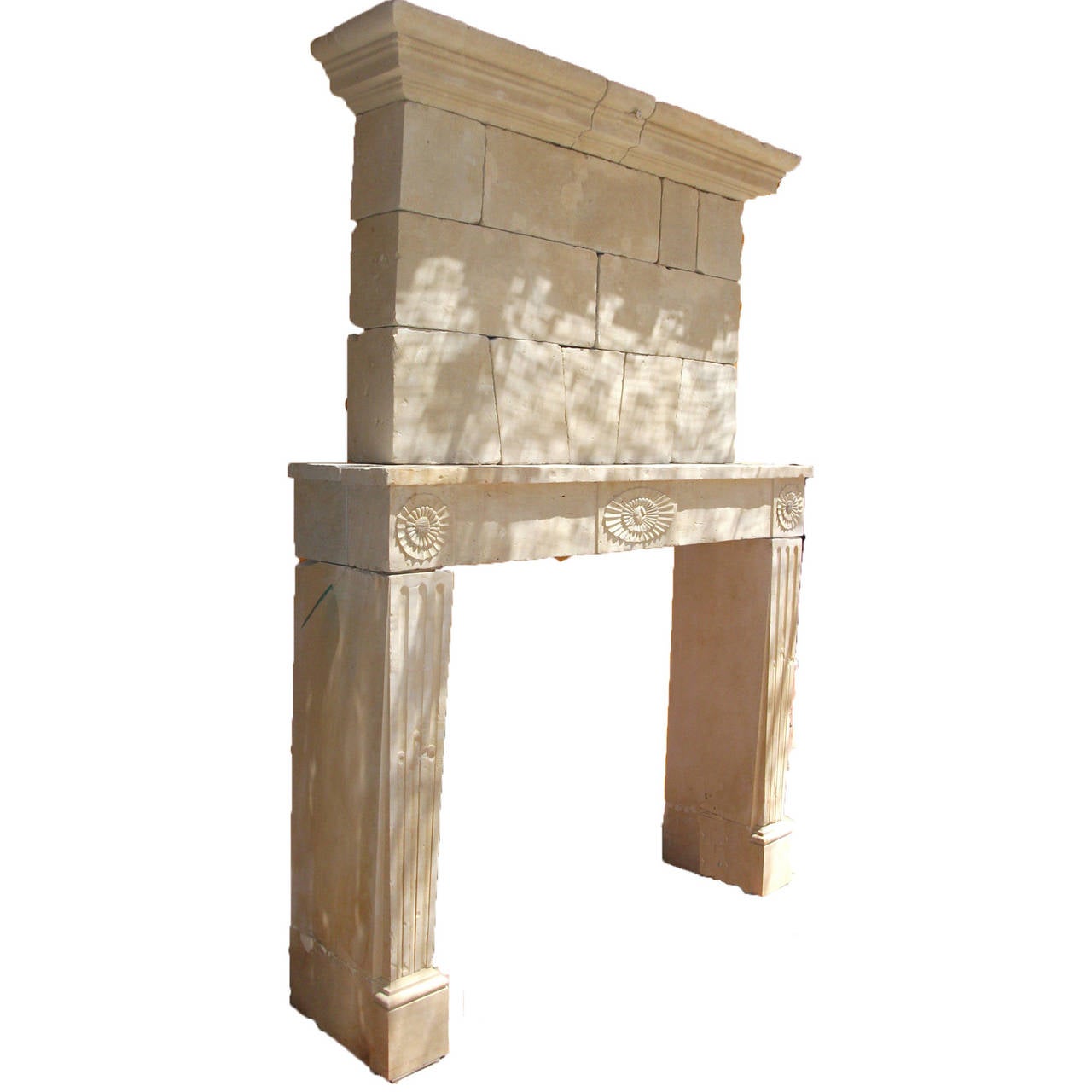 Antique French Limestone fireplace. This Louis XVI style fireplace with pier/trumeau is handcrafted in limestone. This limestone fireplace is in good condition and from the 18th century. Carved accents details on the face of the mantel and along the