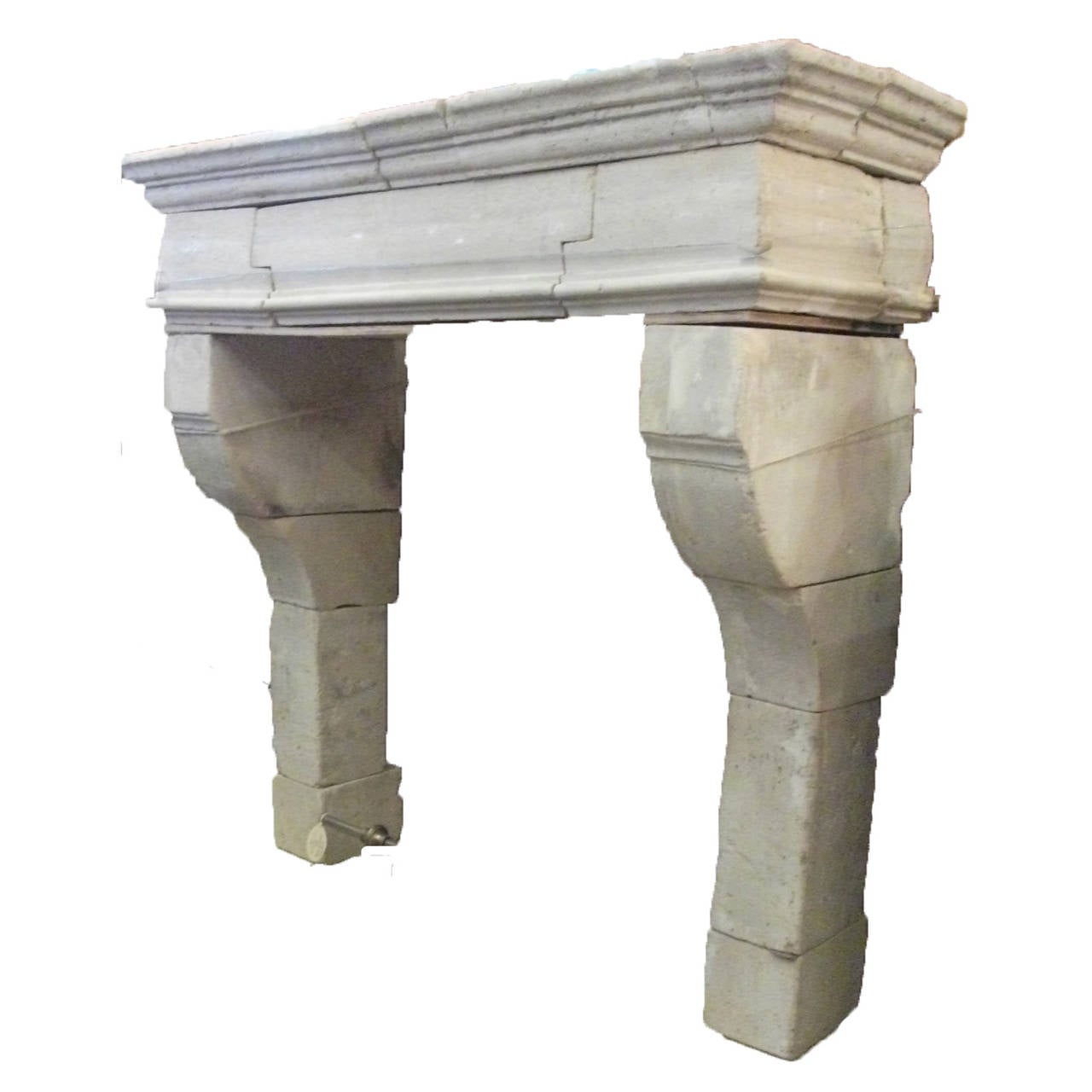 Antique French Limestone fireplace. This Louis XIII style fireplace is handcrafted in limestone. This limestone fireplace is in good condition and from the 18th century. Very bold traditional style mantel with curved accents at the top of the
