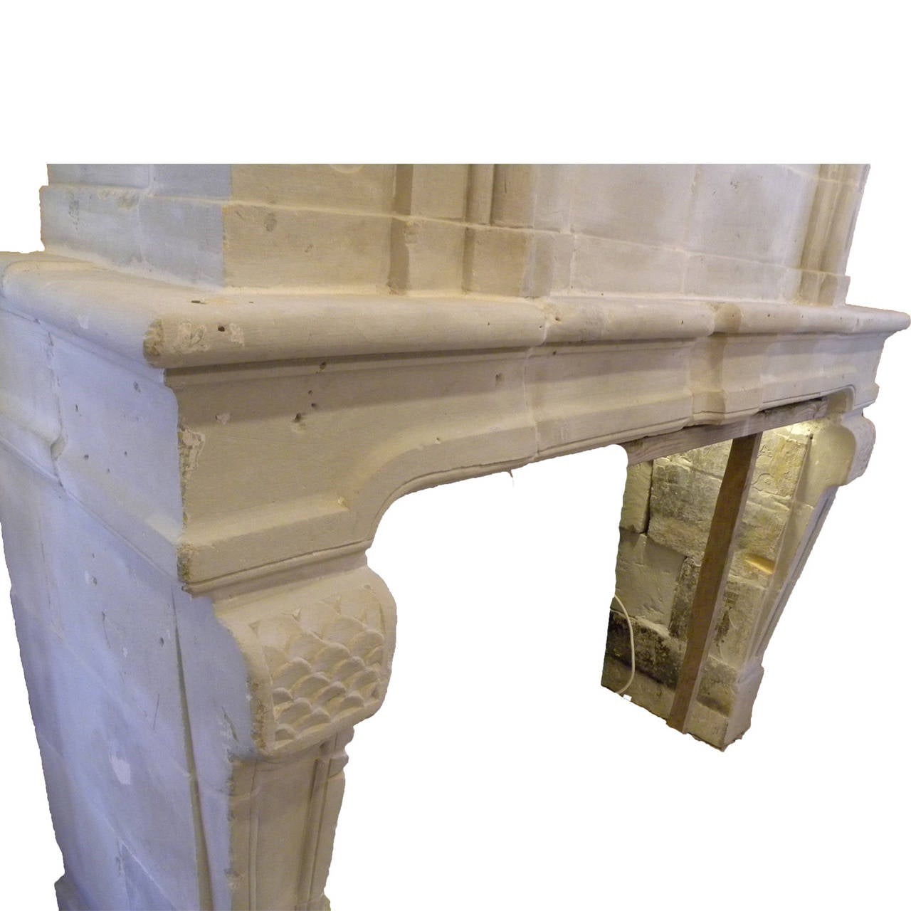 Antique French Limestone fireplace. This Louis XIV style fireplace with pier/trumeau is handcrafted in limestone and from the 18th century. This limestone fireplace is beautiful example of the craftsmanship of the era . Carved accents details on the