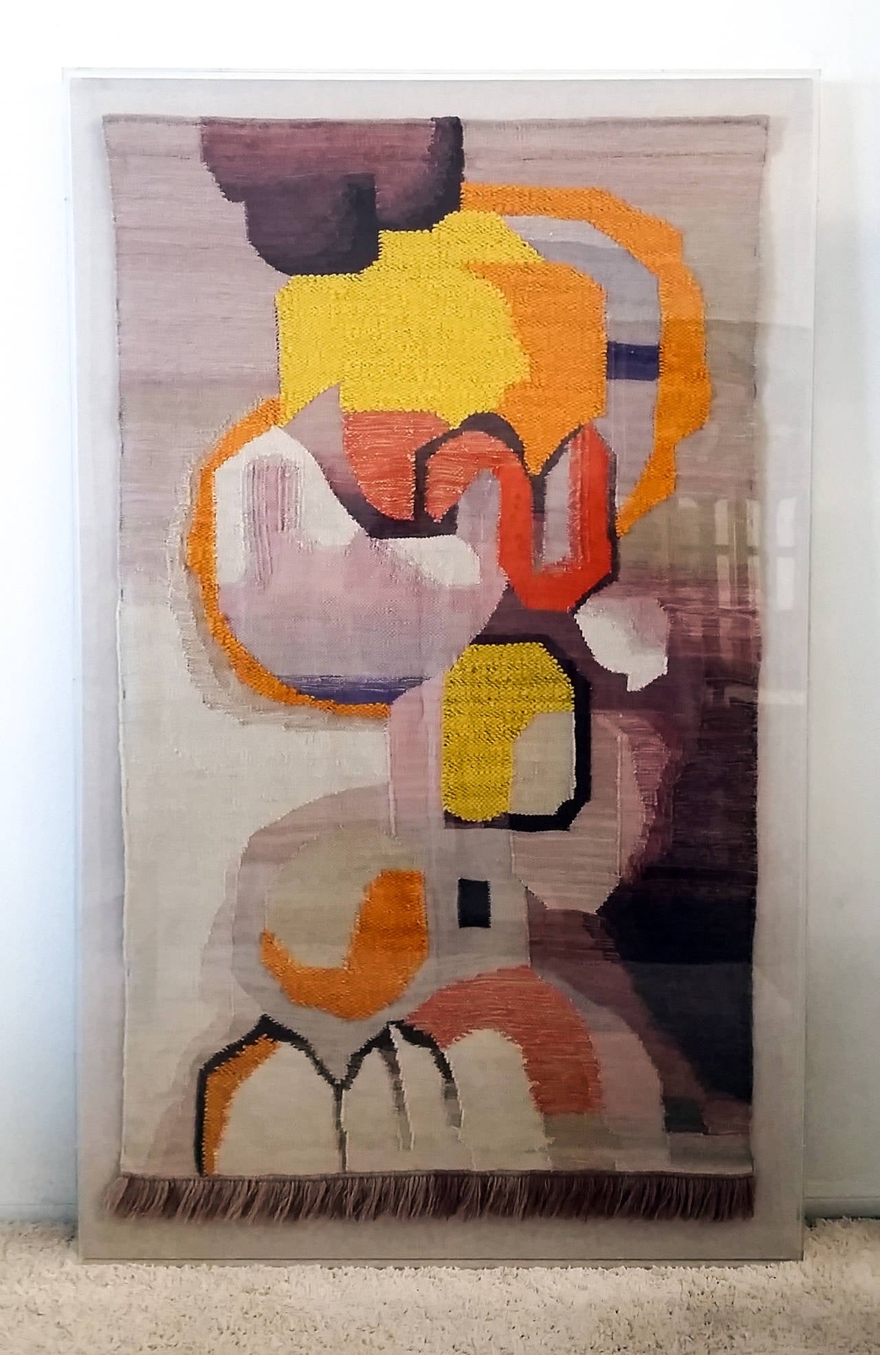 An incredible piece; this tapestry features bold colors and a great Mid-Century abstract design. The tapestry is in mint condition and was professionally framed on a canvas backing enclosed within an acrylic box frame. 

There is one very small