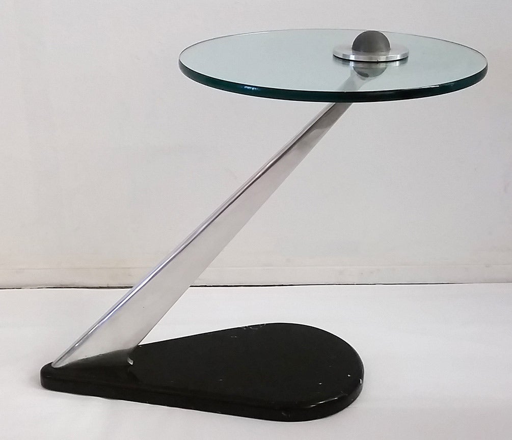 A gorgeous modern side table with a black marble base and glass top in the manner of Vladimir Kagan.