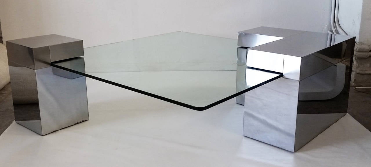 An absolutely stunning coffee table in the manner of Paul Evans. The coffee table is in great condition with wear to commensurate with age. The chrome is a tone on tone brushed and polished effect. 

The glass fits into the recesses of the table,