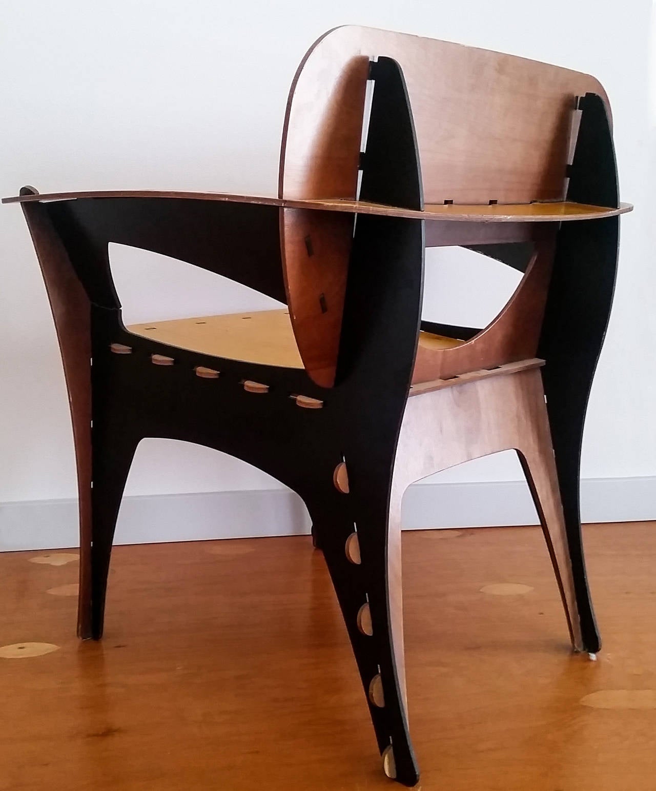 A stunning modern chair designed by David Kawecki, this plywood chair is a comfortable sitting chair as well as a conversation piece. The chair is  glossy birch colored plywood, walnut stained plywood, and ebonized (black painted) plywood.

This