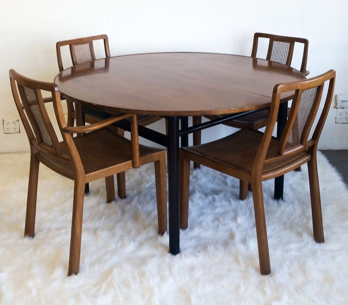 Edward Wormley for Dunbar set of 4 dining chairs and table. The set is all solid walnut with 4 cane / walnut dining chairs (One captain chair and 2 side chairs). 

The set is in good condition with wear to commensurate with age. One of the seat's