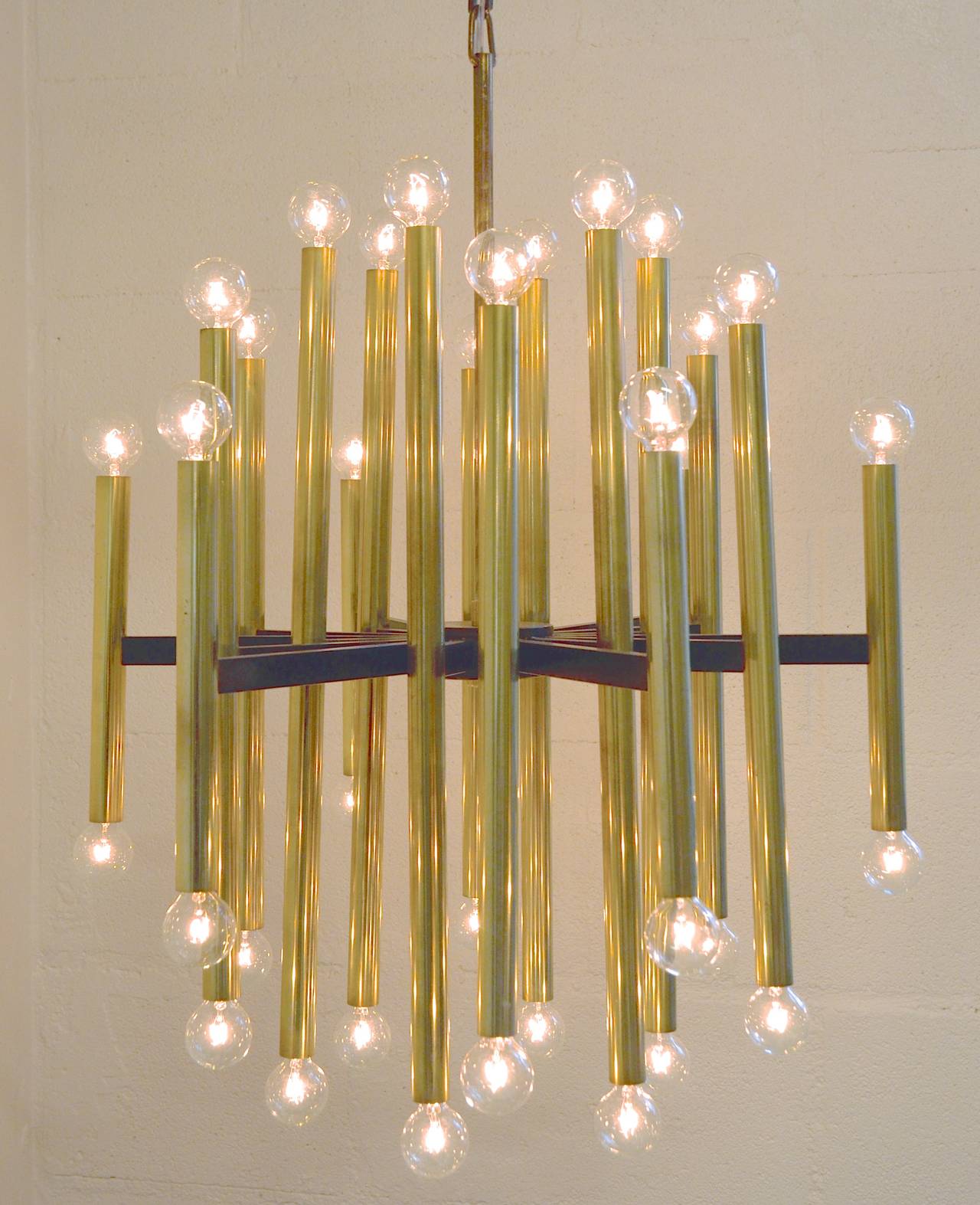Thirty-six-light chandelier by Gaetano Sciolari for Lightolier, Italian, circa 1960. Black spokes radiating from the center support with 18 brass cylinders with sockets at both ends. Includes original hanging rod and canopy. Newly rewired with