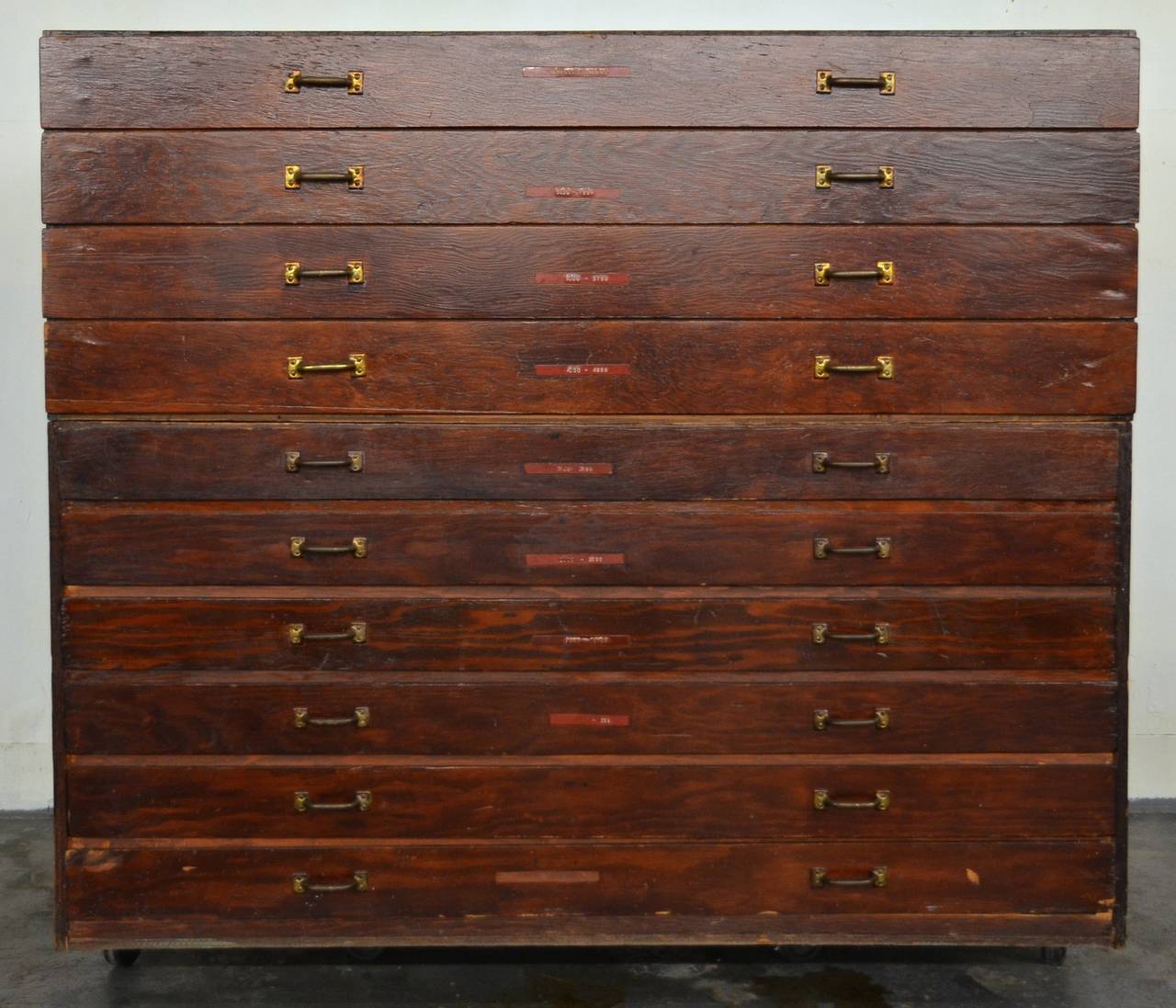 Fabulous flat file with warm stained wood and brass hardware. Authentic style and function for storing architectural drawings, art or maps. Composed of two parts that stack on top of each other with one part having six drawers and the other having