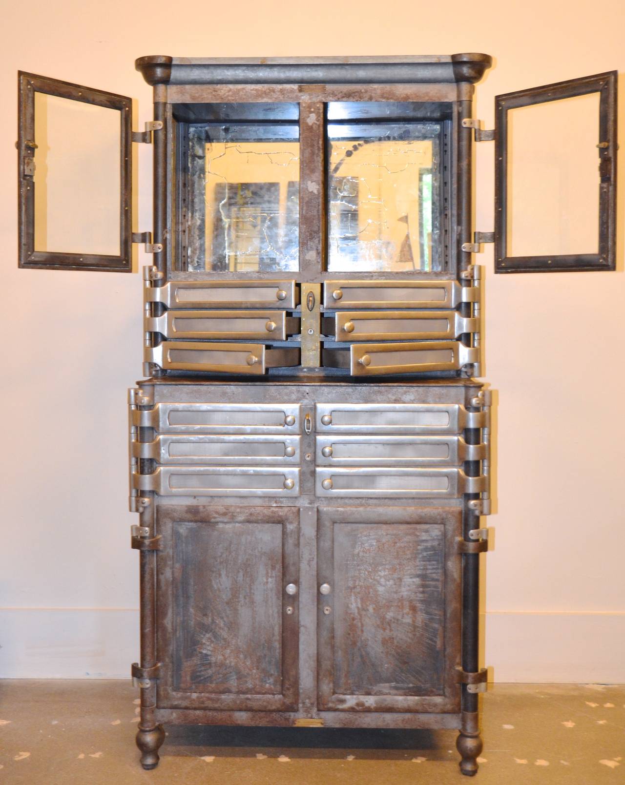 Extraordinary medical cabinet with all operable doors and drawers and original brass latches. The original enamel is stripped, and all steel, brass and nickel is waxed to a subtle sheen. Two lower doors and two upper glass doors with 12 swinging