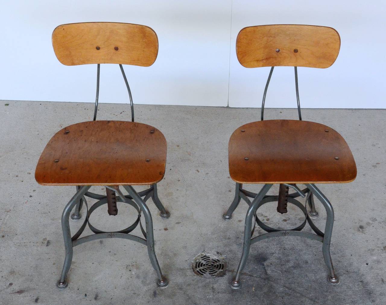 Retaining tags from the Toledo Metal Furniture Company, these iconic chairs have Steampunk flair and authentic Industrial history. Bentwood seats and backs sit on adjustable steel frames. One chair has wheels. Great dining or office chairs.