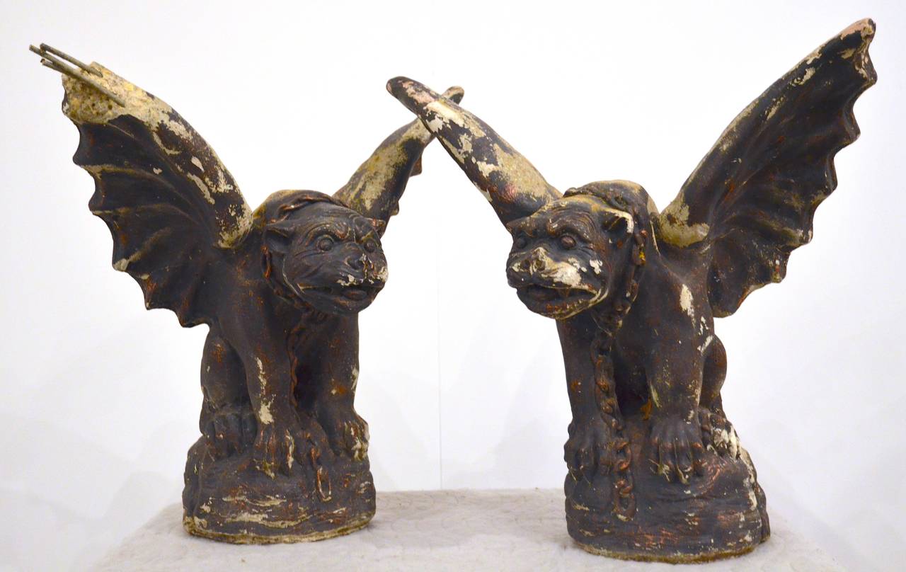 Cast stone gargoyles, with great character, make cool accessories or garden sculpture. The painted finish is distressed and ranges in color from black to maroon. Note: Damage to one wing.