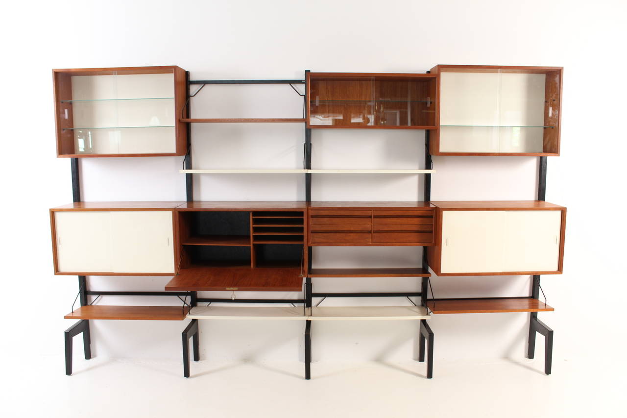 Large teak Royal modular wall unit by Poul Cadovius.
Three cabinets with original glass sliding doors.
Two cabinets with original lacquered doors.
One cabinet with drawers.
One cabinet can be used for writing.

In vintage used condition.