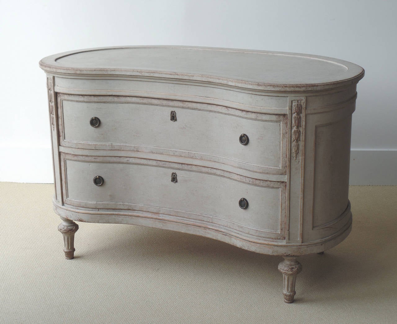 Danish painted kidney-shaped freestanding chest with paneled top, sides and back, two drawers, applied decorations, and turned feet with fluting and ribbon banding. Chest is finished on all sides, made to be float. Lovely sculptural form. Made by