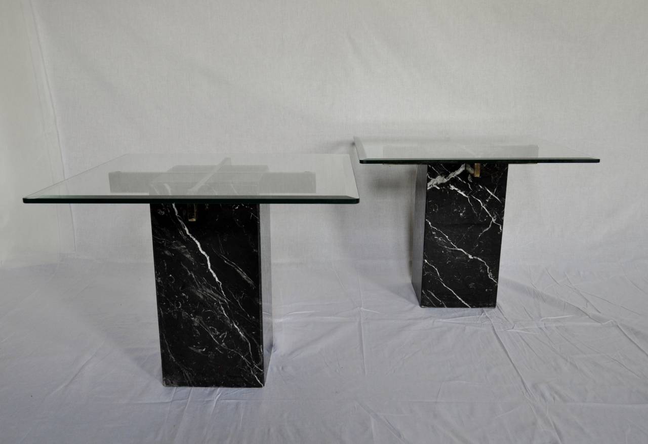 Pair of Italian, black marble side / end tables attributed to Artedi.  Design features a removable crusiform polished brass support and beveled clear glass top.  Tables can also be placed side by side for an interesting and unique cocktail table.
