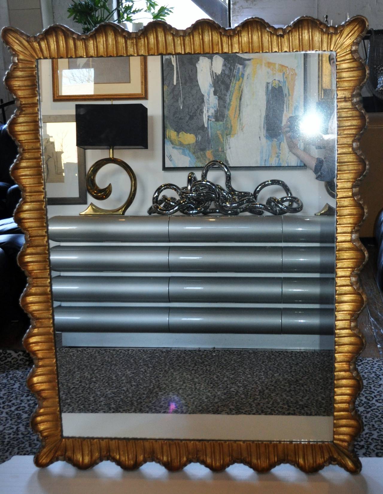 Stunning Venetian mirror with hand-carved scallop design, circa 1950s.
Hand gilded with gold and silver undertones , the amazing wood frame features a deep, sculpted ruffle edge. This gorgeous Italian mirror is a true piece of wall art and can be