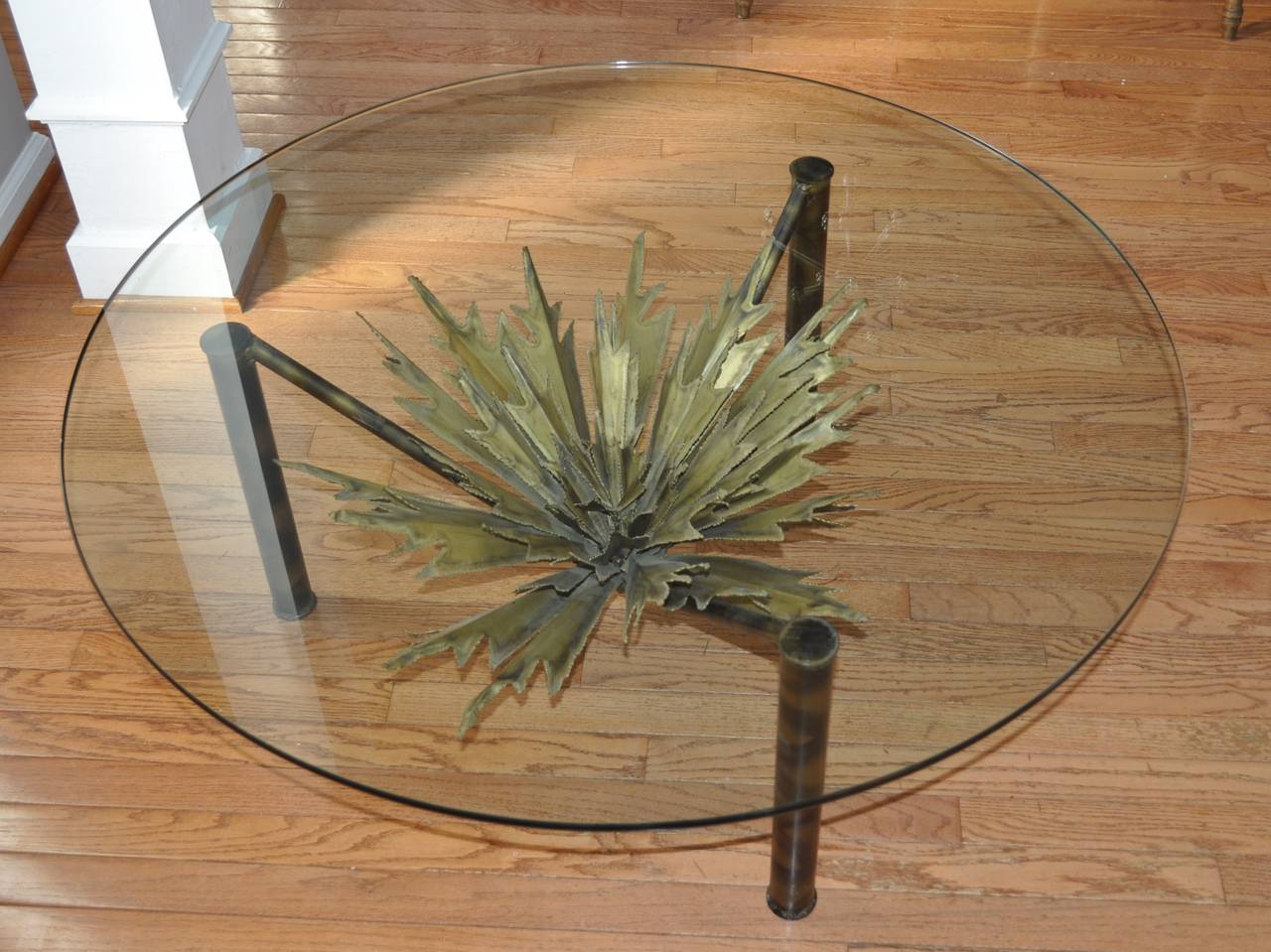 Very rare Brutalist glass and metal cocktail table in the style of Paul Evans and Silas Seandel. A stunning torch-cut mixed-metal sculptural sunburst with brass, copper and steel tones, rests upon the unique three legged metal table base. This piece
