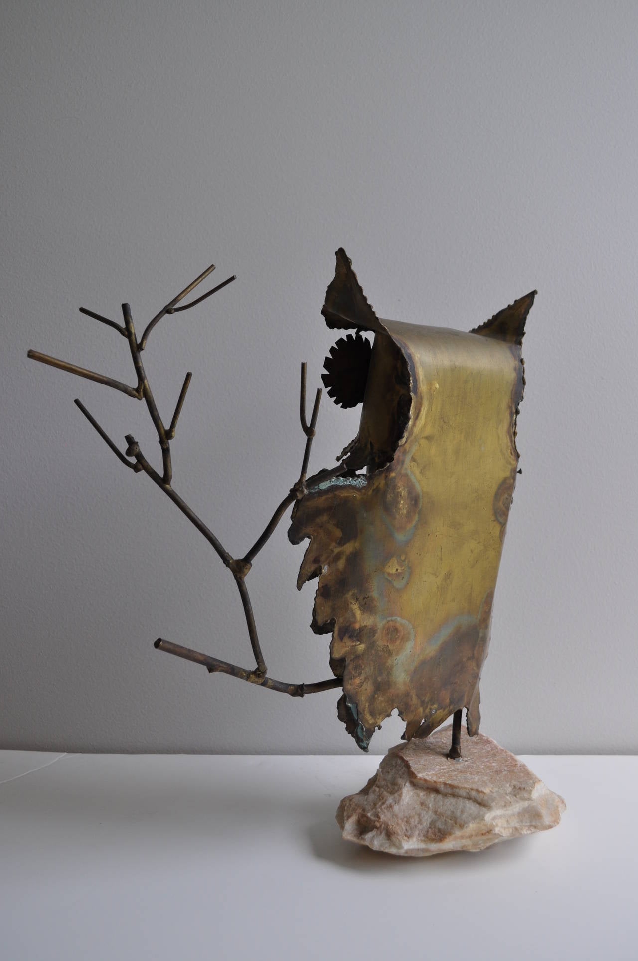 Large and Impressive 1970s Mid-Century Brutalist Torch Cut Metal Owl Figure perched on a tree branch.  In the style of C. Jere.  The animal /bird sculptural figure is mounted to a natural stone base and the figural tree branches are made of