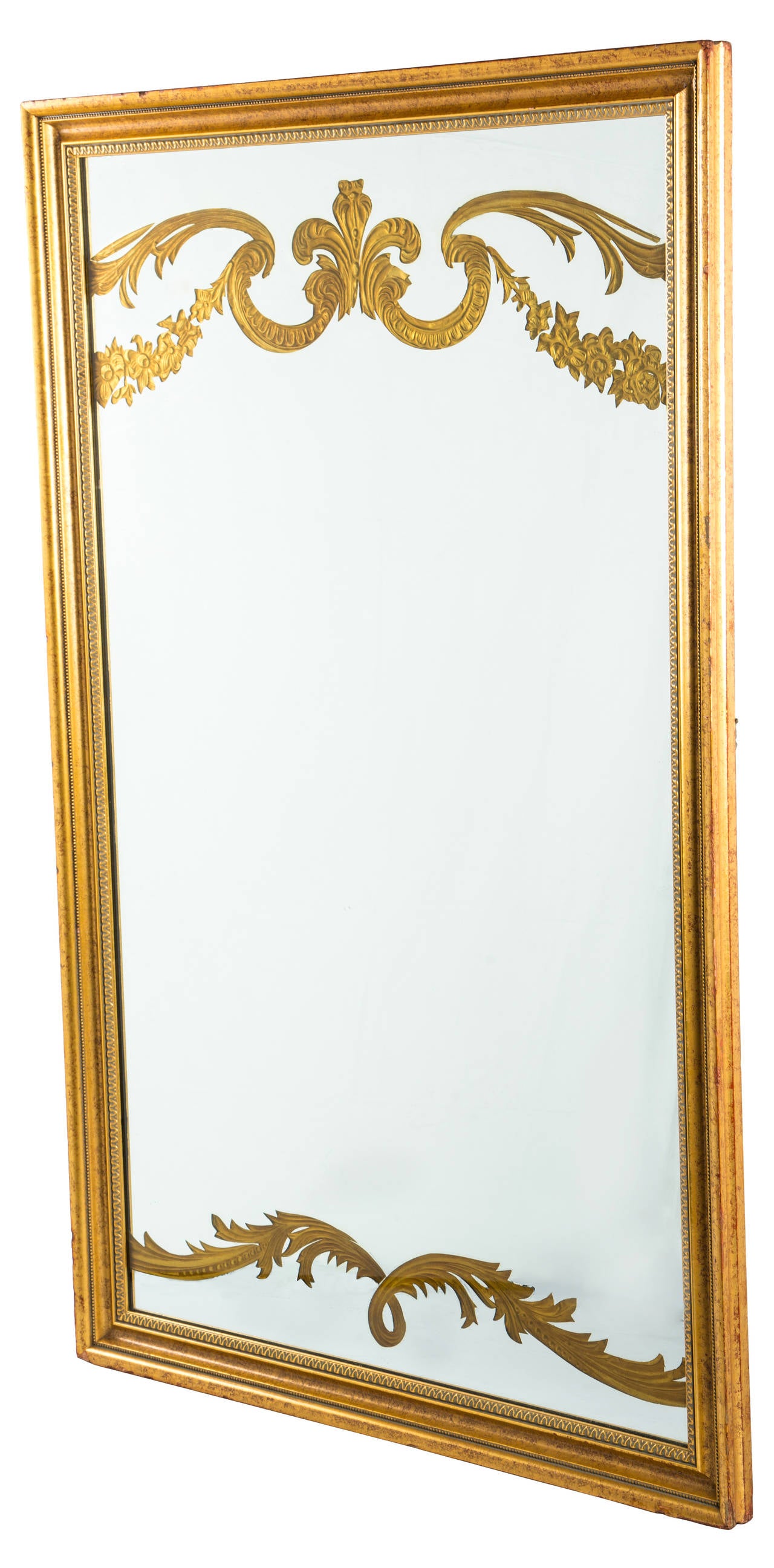 Large Midcentury Modern Hollywood Regency reverse painted gilt mirror featuring decorative Neoclassical French style motif with detailed gold painted wood frame.  In the style of Dorothy Draper.