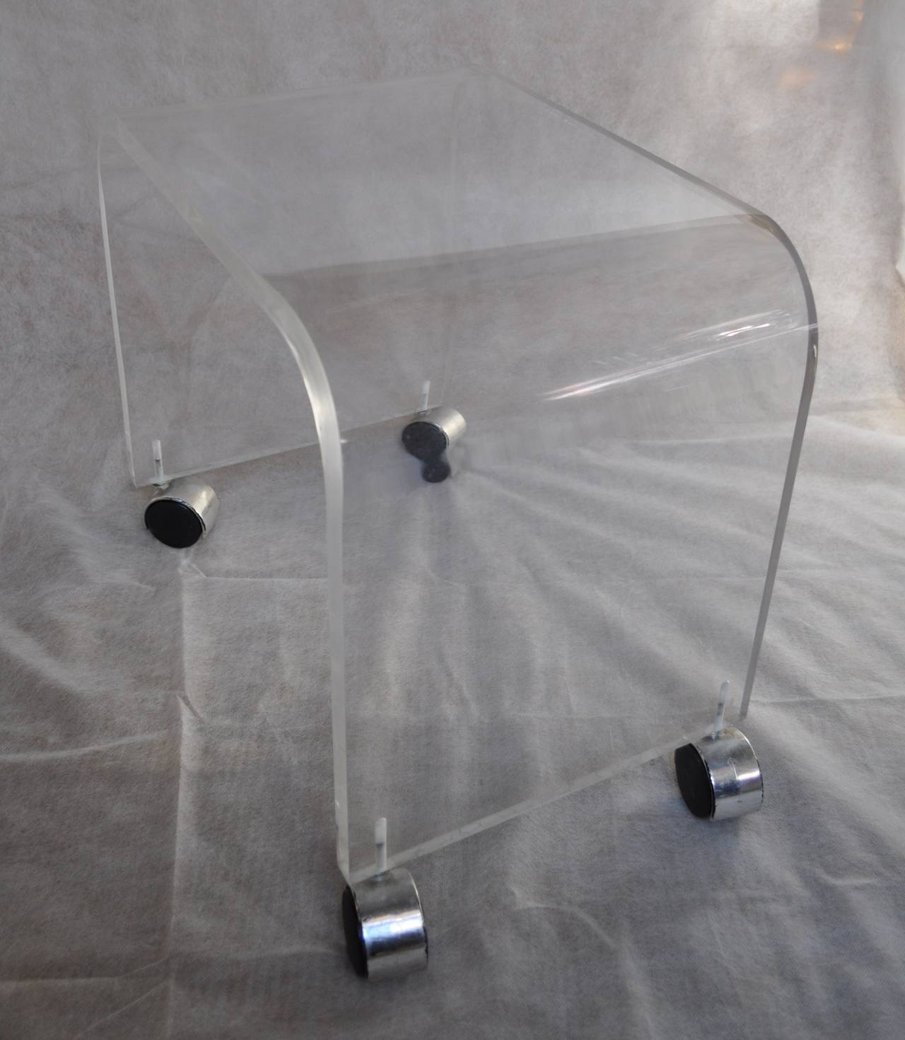 Mid-Century Modern waterfall style Lucite vanity bench or stool with chrome casters.