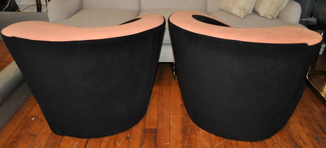 Pair of Nautilus swivel lounge chairs designed by Vladimir Kagan for Directional. Chairs feature original black and blush tone ultra suede upholstery. Swivel bases rotate 180 degrees and return to original position when released.  
