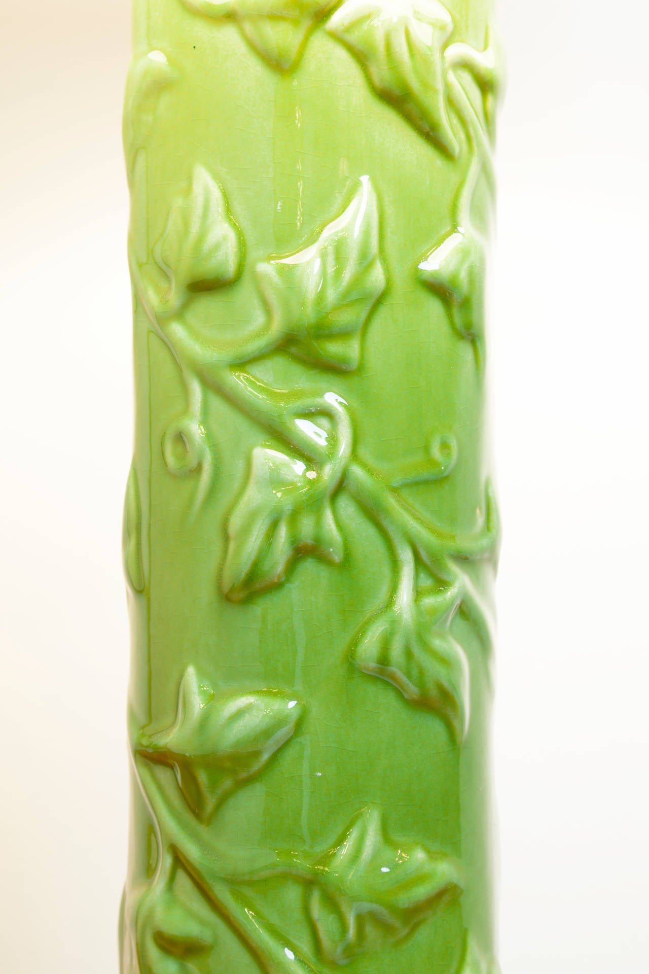 Art Pottery lamp with beautiful lime green glaze and raised vine design, circa 1930s. Overall dimensions including shade: 12 inches wide x 24 inches high.
