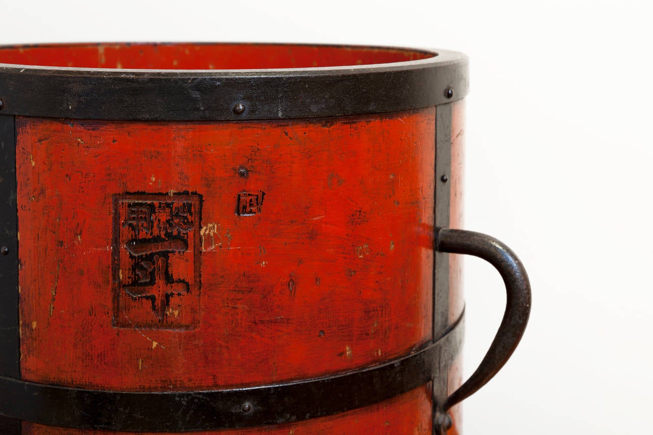 Antique chinese wood and iron bucket, circa 1900. Cinnabar lacquer
with impressed Chinese stamps, bound with iron and iron handles. Diameter measurement includes handles.