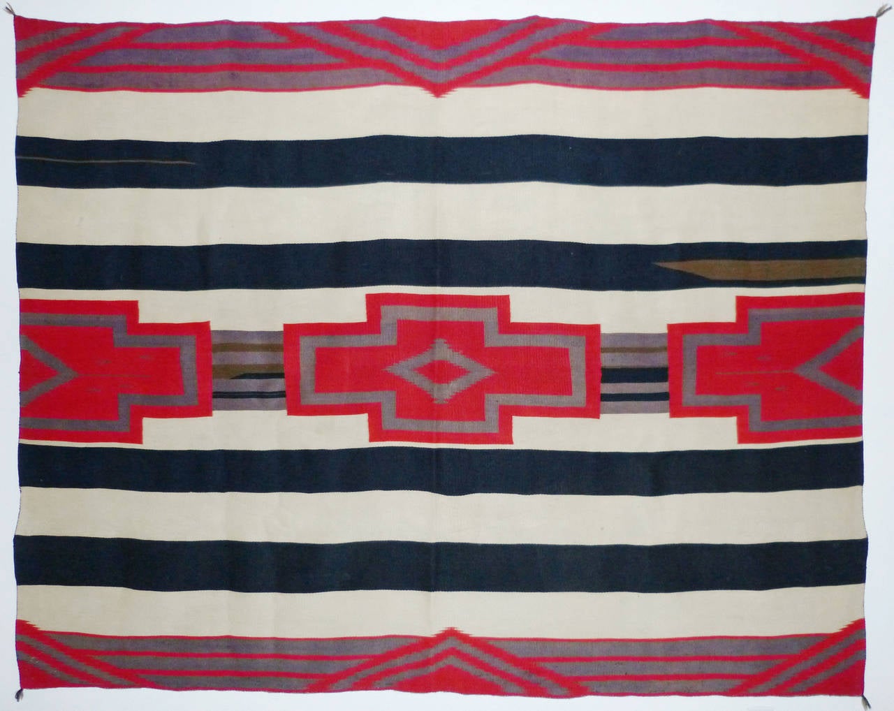 A third phase variant chief’s blanket, circa 1890's. Woven from commercially spun and dyed wool with a banded background and cross motifs. Chief blanket is a misnomer, as the Navajo tribe has a clan system, there were no chiefs. However, prominent