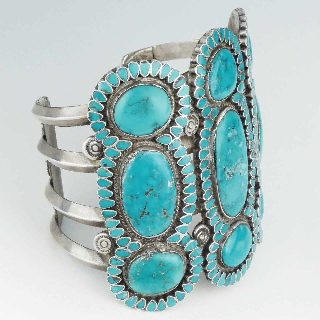 A fantastic example of Frank Dishta’s work, c. 1950. Dishta worked primarily in channel inlay and made jewelry for C.G. Wallace, the trader at Zuni. This bracelet features over 200 individual teardrop shaped stones juxtaposed against extremely large