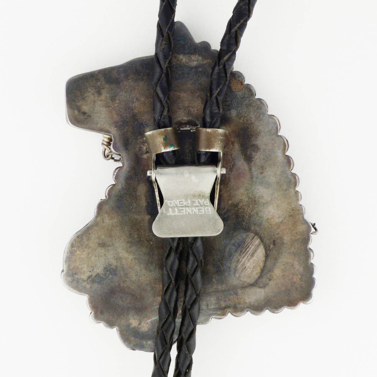A wonderful Zuni Pueblo bolo tie, made from hand-carved jet, inlaid with turquoise and mother of pearl, set in silver, representing a horse and its bridle. Bolo tie is made of hand-braided leather with silver terminals.  2 1/4