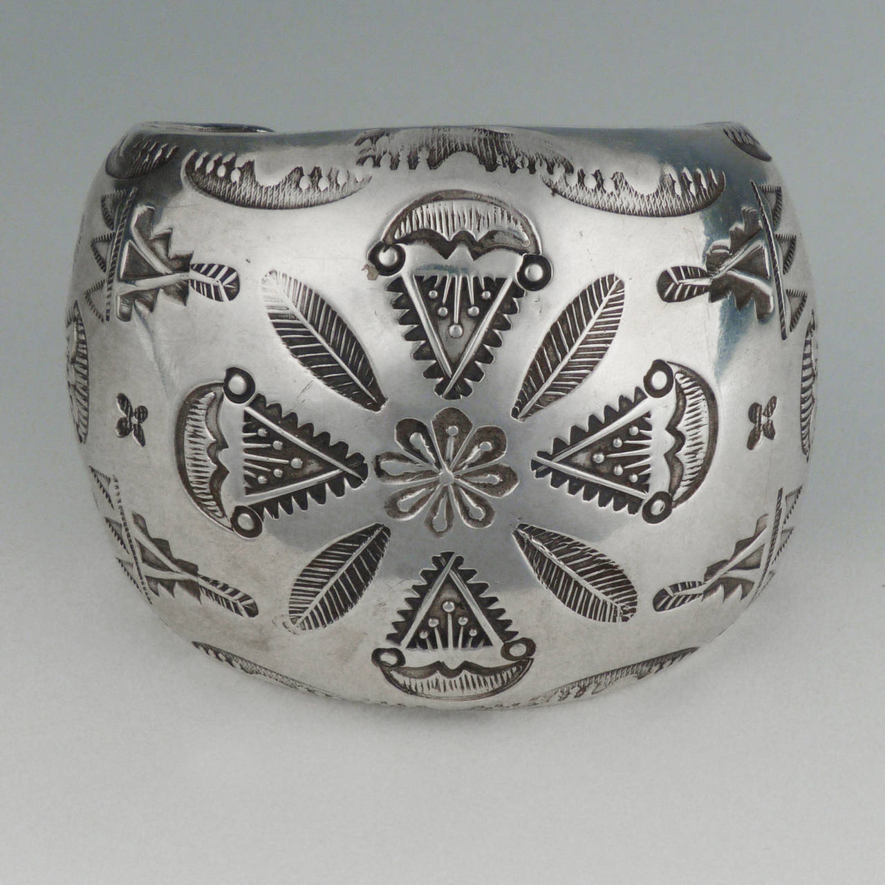 This vintage sterling silver cuff by renowned Hopi silversmith Ralph Tawangyawma (1894-1972) features a beautiful domed shape and ornate stamping. Formed entirely from two uniform pieces of heavy gauge sterling silver, the piece has a large presence