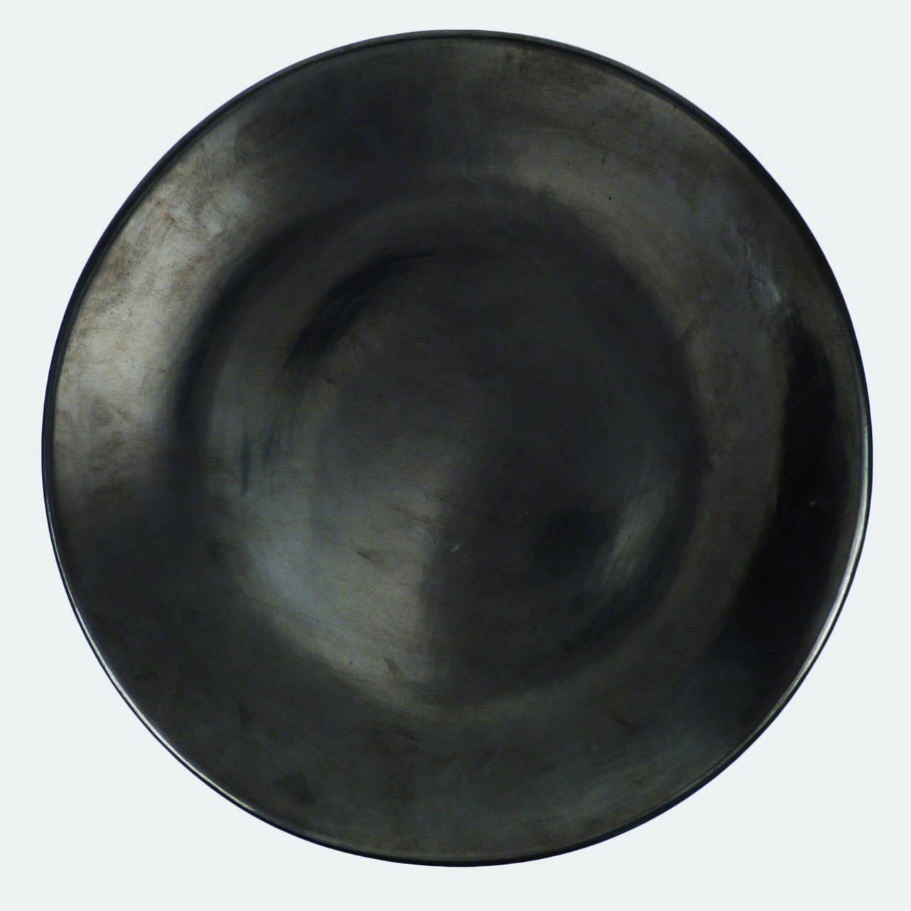 This polished black plate is a masterpiece by mother and son potters, Maria Martinez and Popovi Da of San Ildefonso Pueblo. Maria/Popovi is one of the most sought after signatures in Pueblo pottery. The plate most likely dates from the mid 1950's.