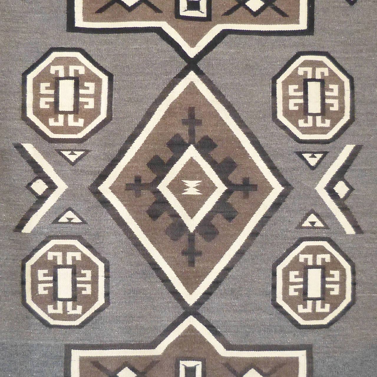 Handwoven by an unknown Navajo weaver in the beginning part of the 20th century, this rug was originally produced for the mail order catalog of the Crystal Trading Post in New Mexico. The owner, J.B. Moore worked directly with Navajo weavers to