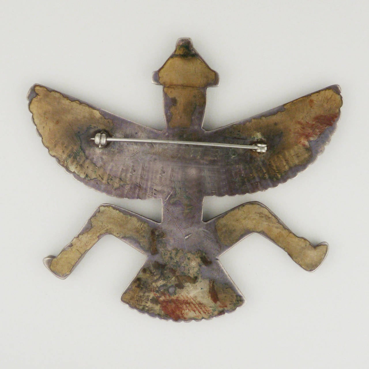 An exceptionally large and fine inlaid pin from Zuni Pueblo, made of spiny oyster, turquoise, jet, white clam shell and sterling silver. This pin represents Knifewing, the Zuni god of war. This symbol was worn by warriors to protect them in battle,
