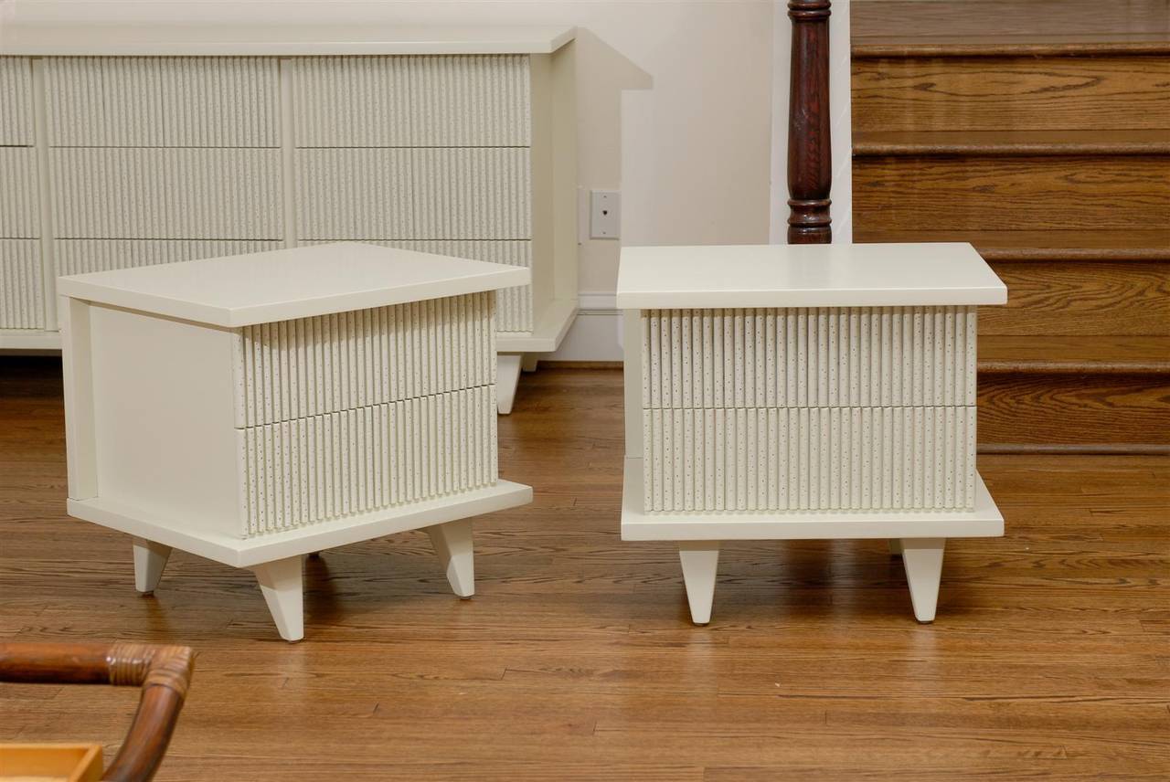 A fabulous pair of end tables or nightstands from a rare series by American of Martinsville, circa 1950. Stout, expertly made mahogany case construction finished in cream lacquer. Beautiful wormhole detail on the drawer front adds the element of