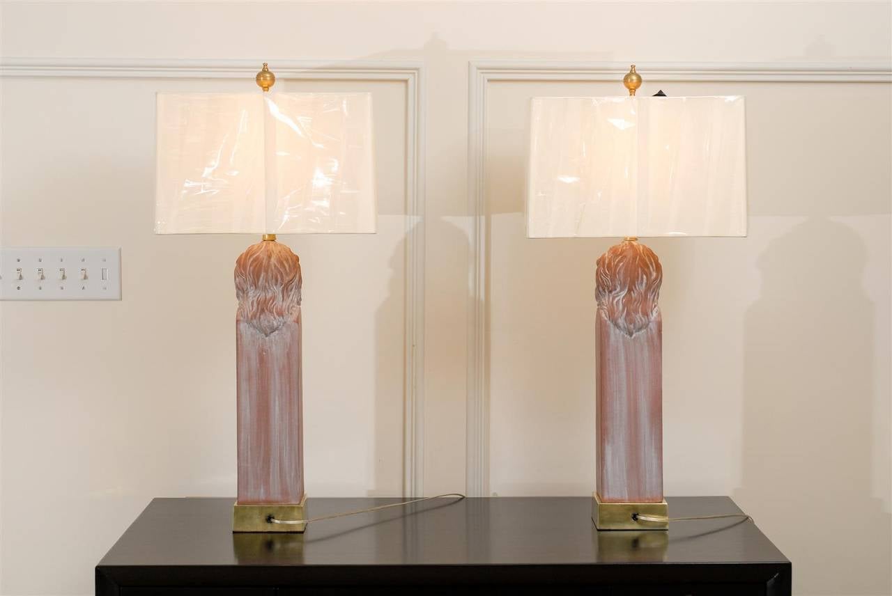 An exceptionally beautiful pair of large-scale stylized lion head lamps, circa 1970. Aged terracotta with natural calcium deposits which highlight wonderful sculptural detail. Solid brass accents with lovely patina.  Magnificent jewelry designed to