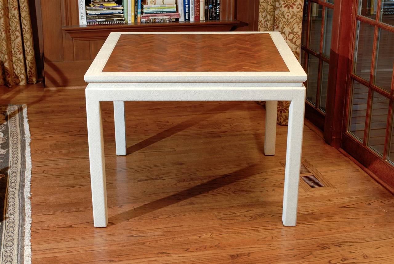 A Stellar vintage game table.  Hardwood construction covered in cream raffia and highlighted by a beautiful inset walnut parquet top.  This expertly made modern piece displays the wonderful union of warmth and texture.  While the table is unmarked,