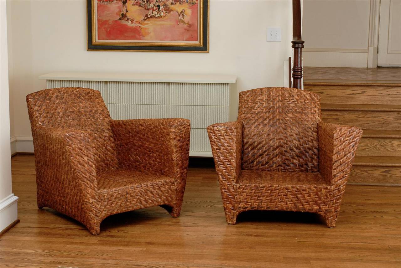 A beautiful pair of vintage rattan club chairs.  Natural raffia veneer over a stout chair frame.  Rich and warm pieces with wonderful color and depth.  Excellent Restored Condition, the chairs have been re-lacquered.  Seat height listed assumes a