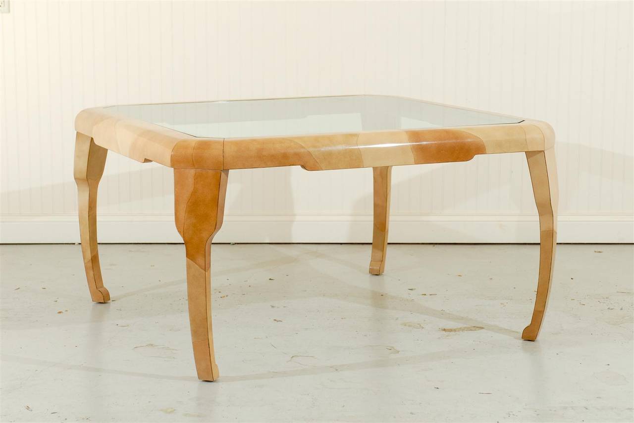 An unusually beautiful dining or game table from the limited Alessandro for Baker Furniture production, circa 1981.  Exquisite hardwood form highlighted by fabulous leg and apron detail, with a glass inset top.  The lacquered faux goatskin finish is
