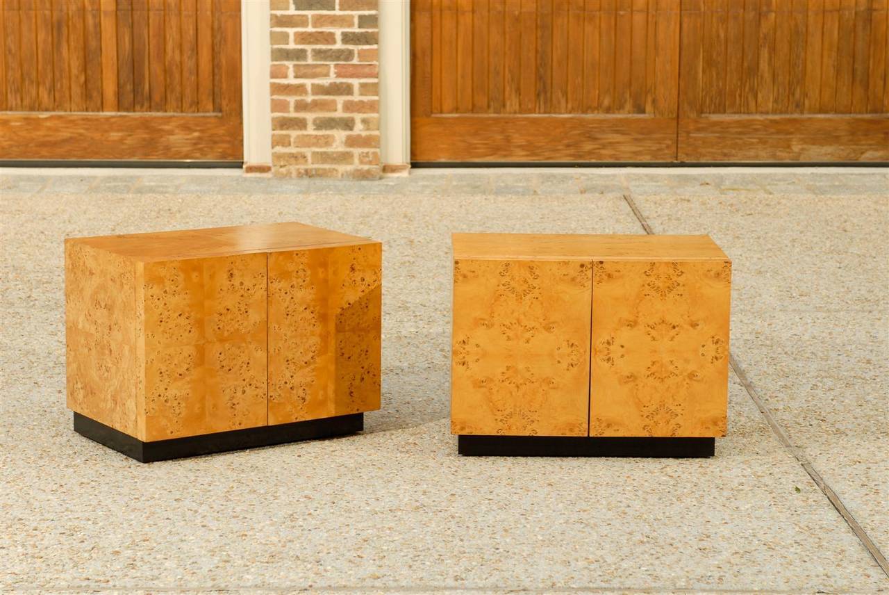 A stellar pair of bookmatched olive wood cabinets mounted atop a simple black lacquer plinth. Fine, expertly made pieces. Functional size allows for use as end tables or nightstands. While the cabinets are unmarked, they are consistent with the Milo